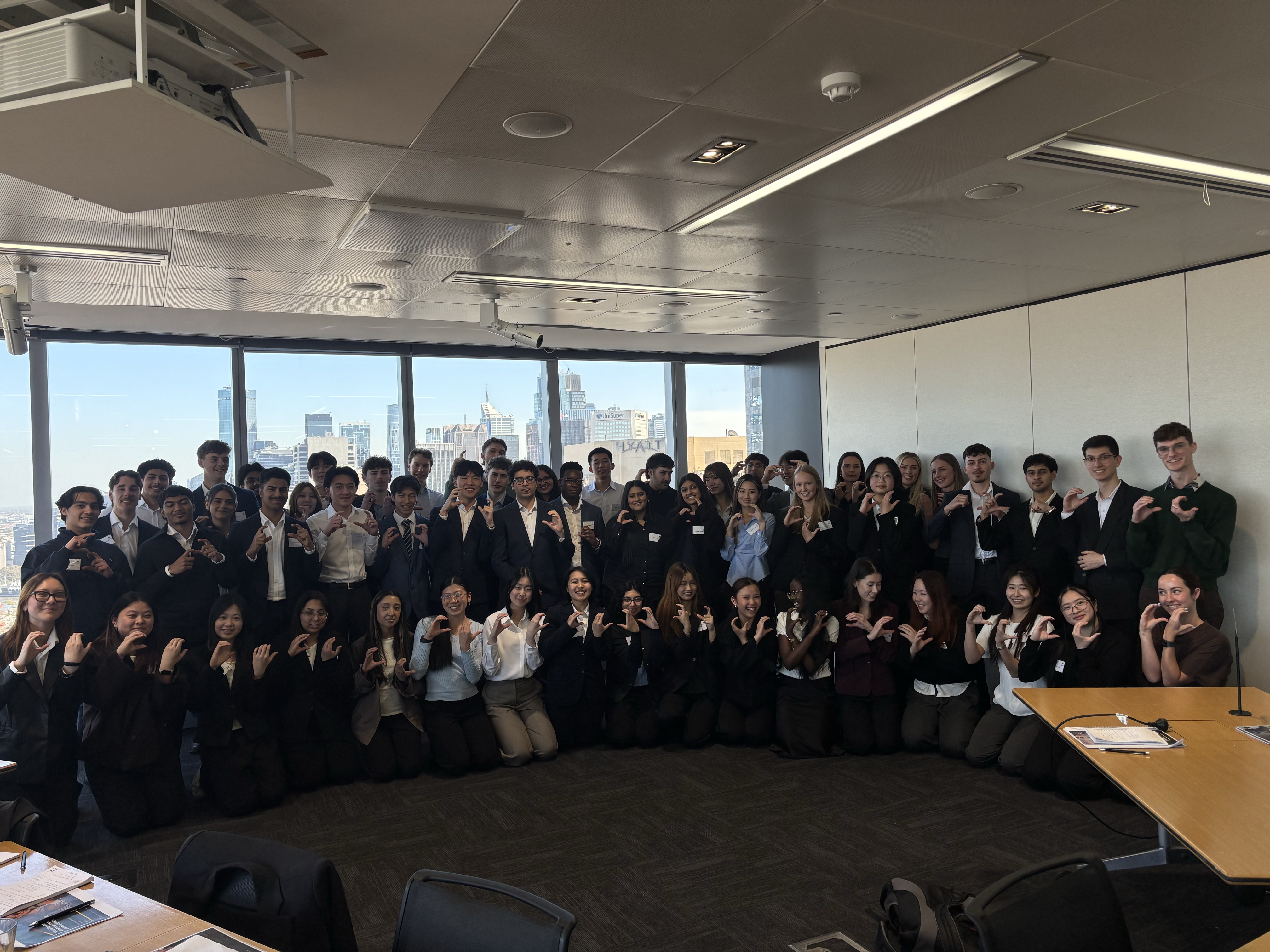 A group posing together in an office overlooking the city
